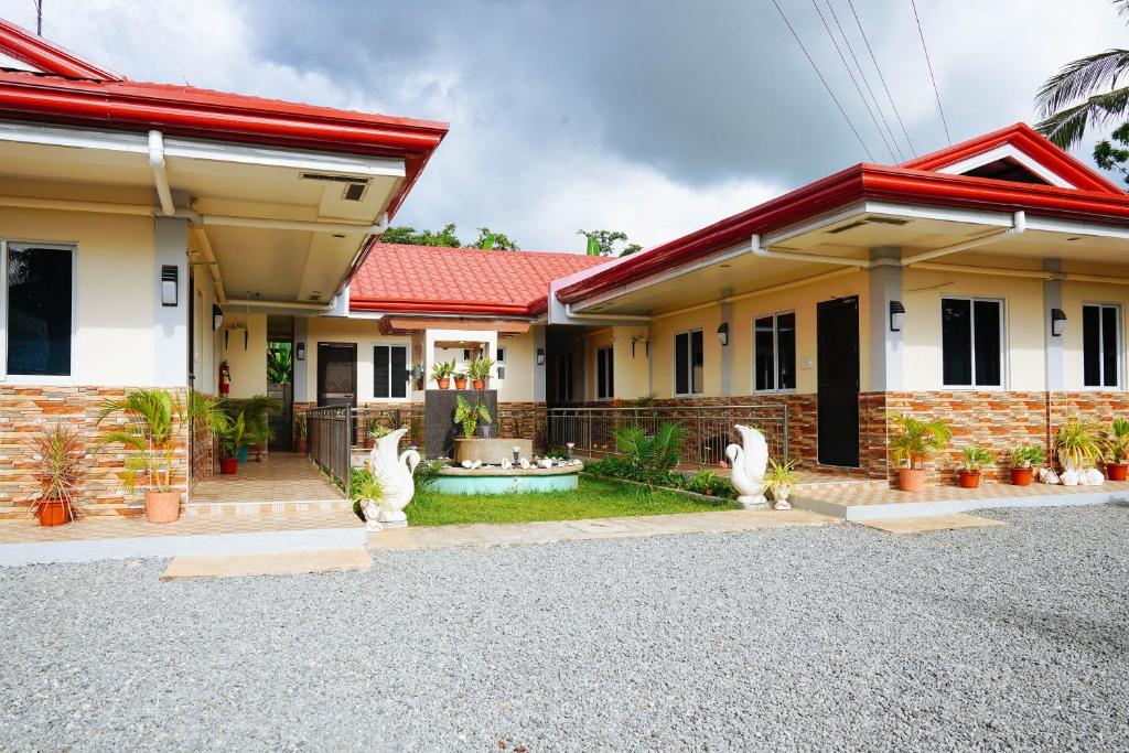 a home with a red roof at AJ Residences Apartelle Camotes RedPartner in Esperanza