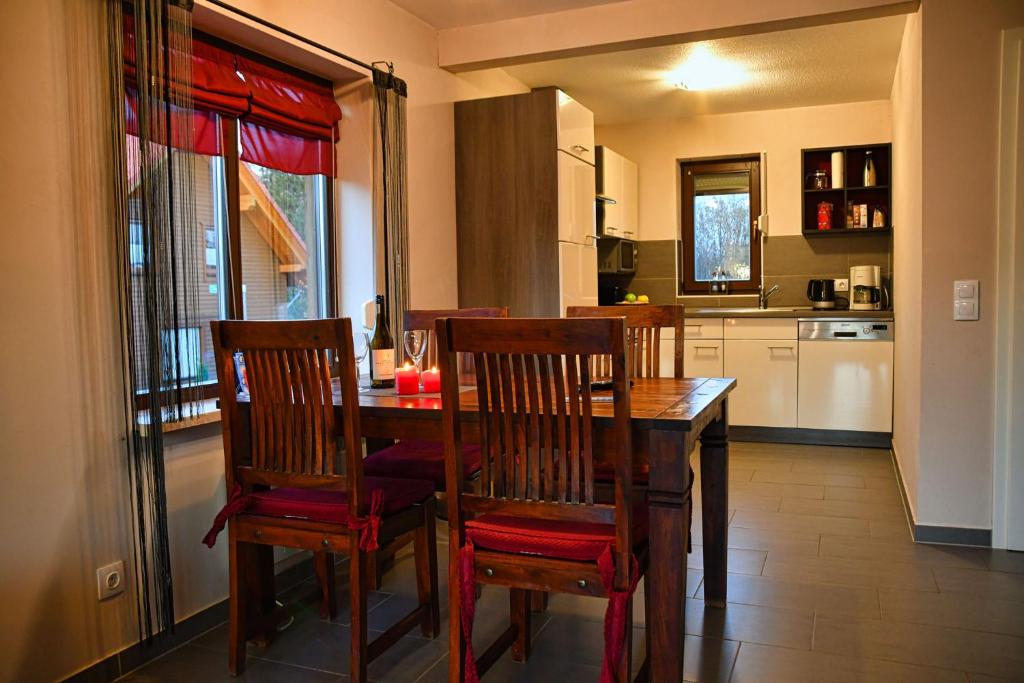 une salle à manger avec une table et des chaises et une cuisine dans l'établissement Auerhahn Ferienhäuser Auerhahn 403, à Hahnenkopf