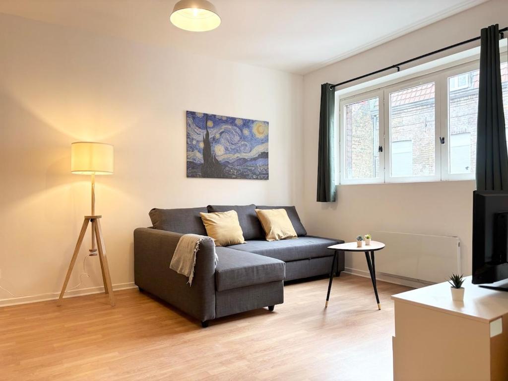 un salon avec un canapé et une fenêtre dans l'établissement Spacieux appartement pour 6 voyageurs - Roubaix, à Roubaix