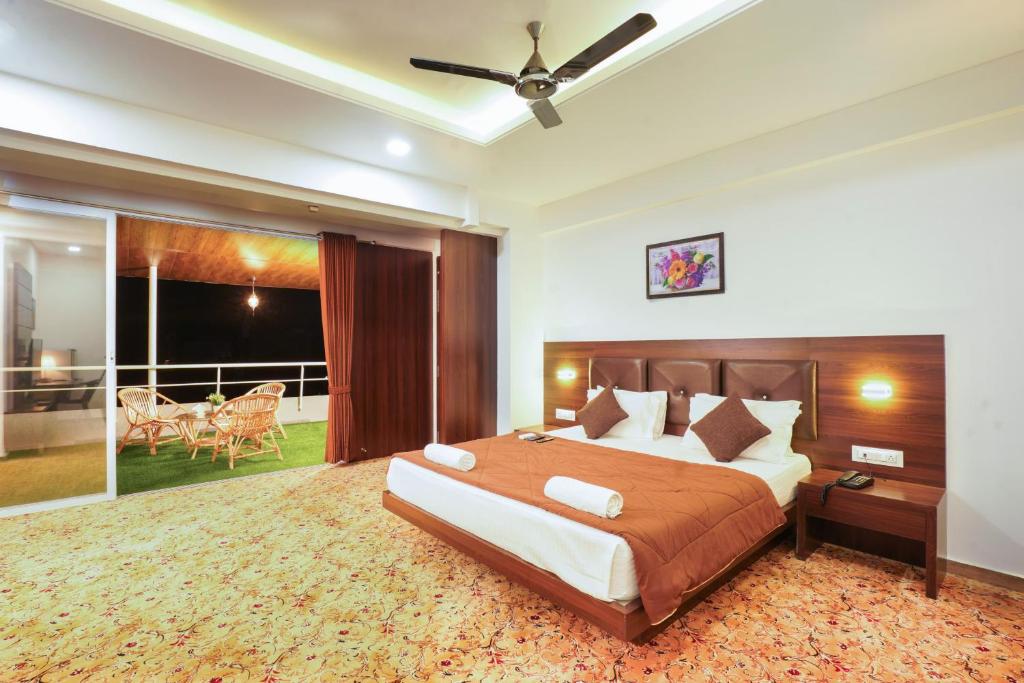 a bedroom with a large bed and a balcony at Sayaji Lodging in Gārgoti