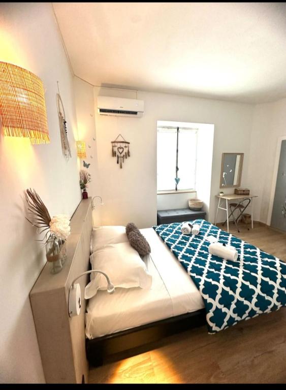 une chambre avec un lit avec une couverture bleue et blanche dans l'établissement L'Alizia, à Sari-Solenzara