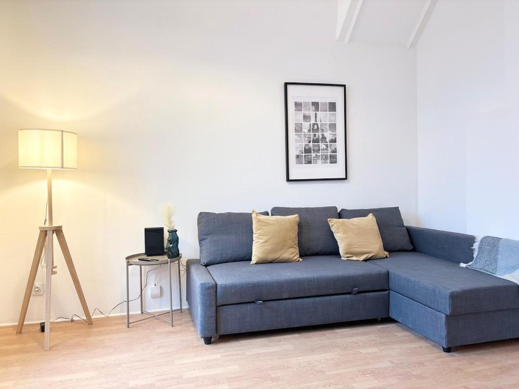 - un canapé bleu dans le salon avec une lampe dans l'établissement Hypercentre de Roubaix - 4 voyageurs, à Roubaix