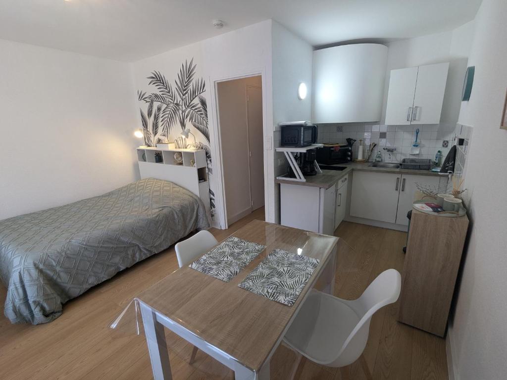 Cette chambre comprend une table, un lit et une cuisine. dans l'établissement Studio Rue Castellane pour Cure ou Tourisme Vert à 2 min des Thermes, à Amélie-les-Bains-Palalda