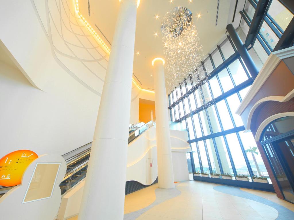 a lobby with escalators and a chandelier in a building at Hotel Universal Port Vita in Osaka