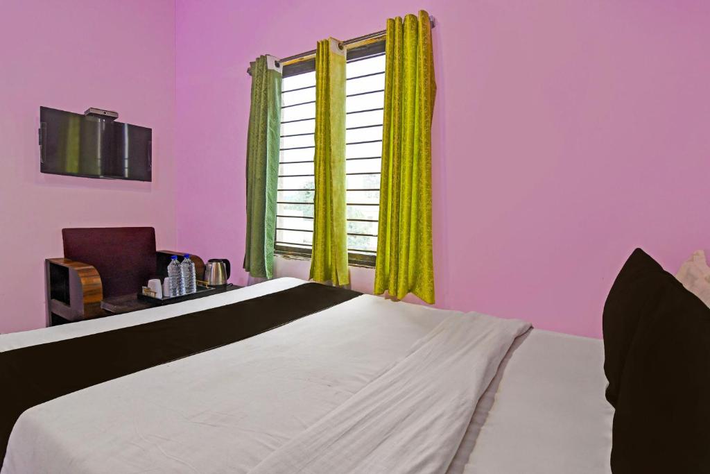 Postel nebo postele na pokoji v ubytování Hotel O Sai Somu Inn