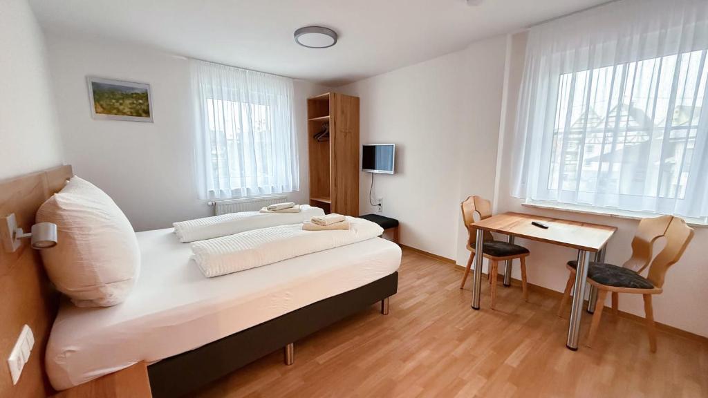 a bedroom with a bed and a desk and window at Landgasthof Sonne in Unlingen