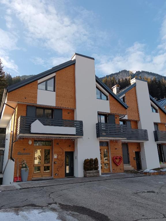 a white building with wood at Appartamento 2 Residenza RODODENDRO in Campitello