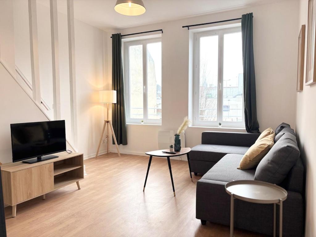 a living room with a couch and a tv at Duplex rénové pour 6 voyageurs - Roubaix in Roubaix