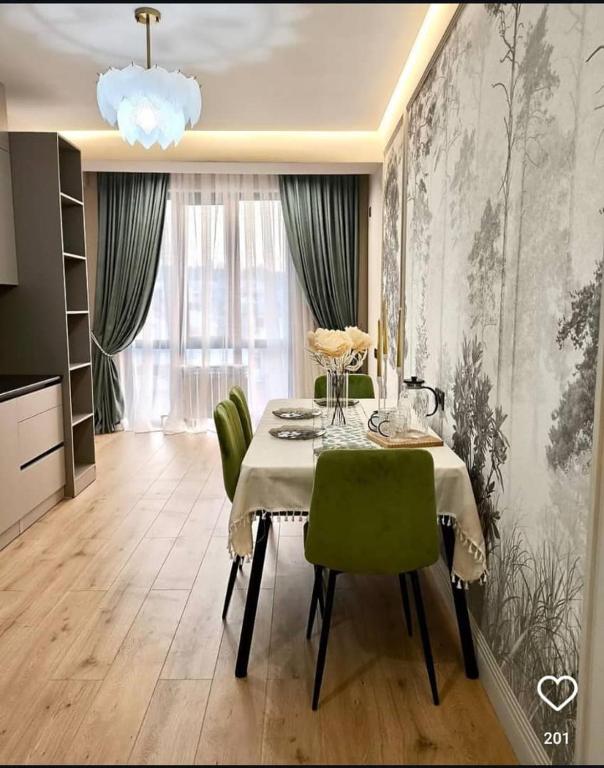 オシにあるResidenceのテーブルと緑の椅子のあるダイニングルーム