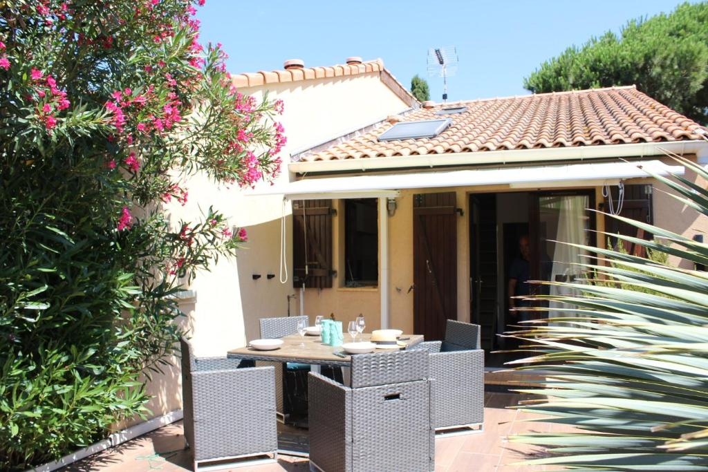 une table et des chaises devant une maison dans l'établissement Maison 2 pièces mezzanine - Gruissan GN020-071, à Gruissan