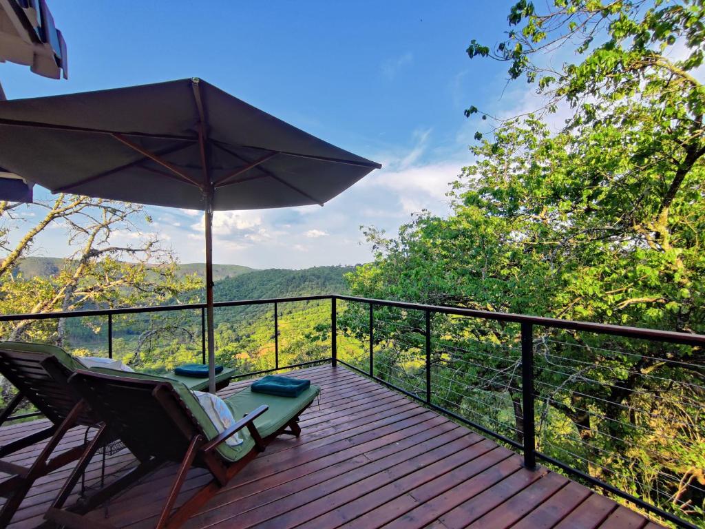 a deck with a chair and an umbrella at The Loft in Kiepersol