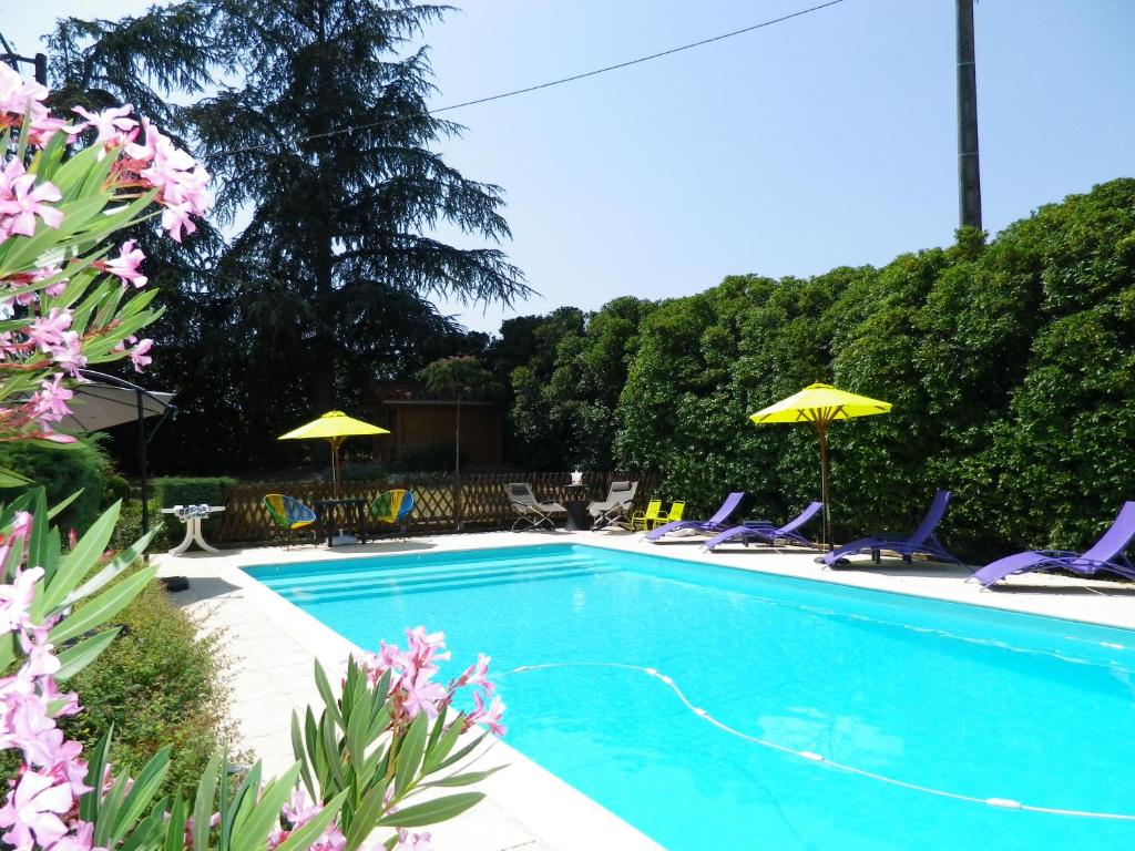 a swimming pool with chairs and umbrellas at Séjour authentique-Piscine Privée Chauffée- Spa et Nature in Beauville