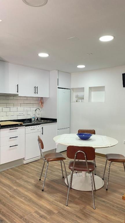a kitchen with a table and two chairs and a counter at Casa da Ti Paqueta in Sabugal