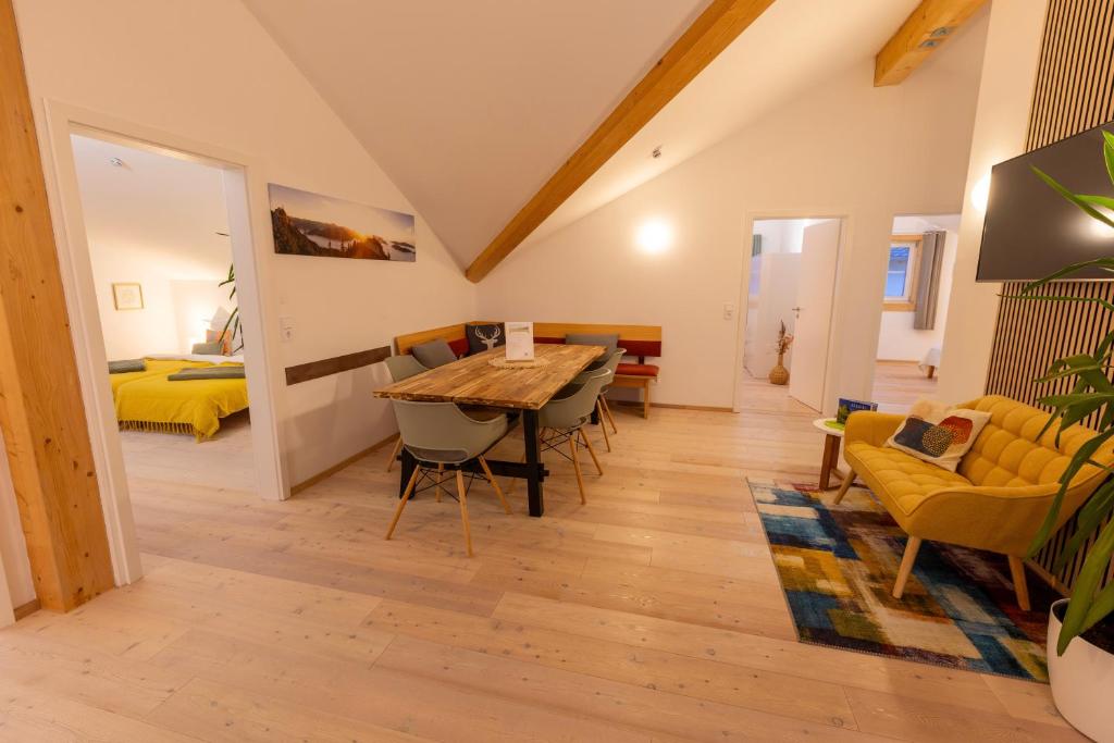 ein Wohnzimmer mit Tisch und Stühlen und ein Schlafzimmer in der Unterkunft Gaul Lodge - für bis zu 8 Gäste, inkl Königscard, 4 Schlafzimmer, 2 Bäder, große Küche, gratis Parken & WLAN, Self Check-in in Nesselwang