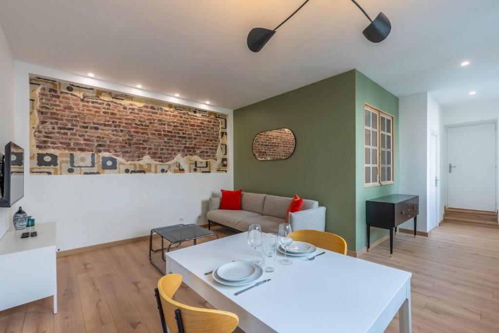 un salon avec une table et des chaises blanches dans l'établissement Appartement une chambre avec parking, Vieux Lille, à Lille