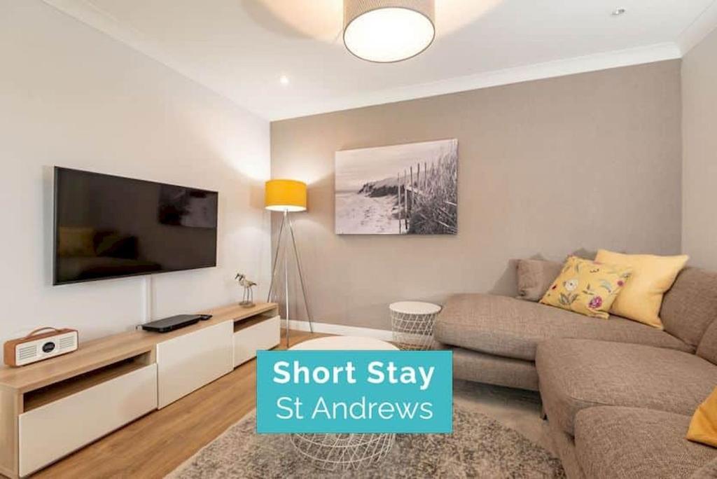 a living room with a couch and a flat screen tv at Abbey Villa - No 5 in St. Andrews