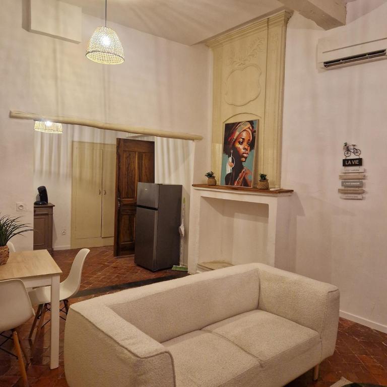 a living room with a couch and a refrigerator at Appartement centre ville de malaucene in Malaucène