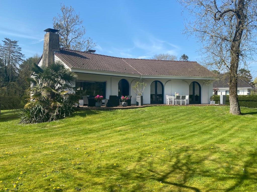 une maison avec une cour herbeuse devant elle dans l'établissement Belle propriété très bon emplacement, à Le Touquet-Paris-Plage