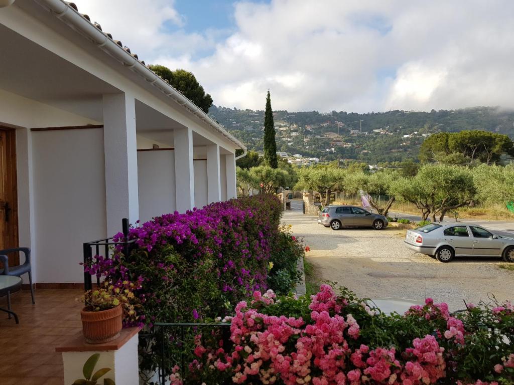 a building with flowers in front of a parking lot at Apartamento Nuevo Ondina in Begur