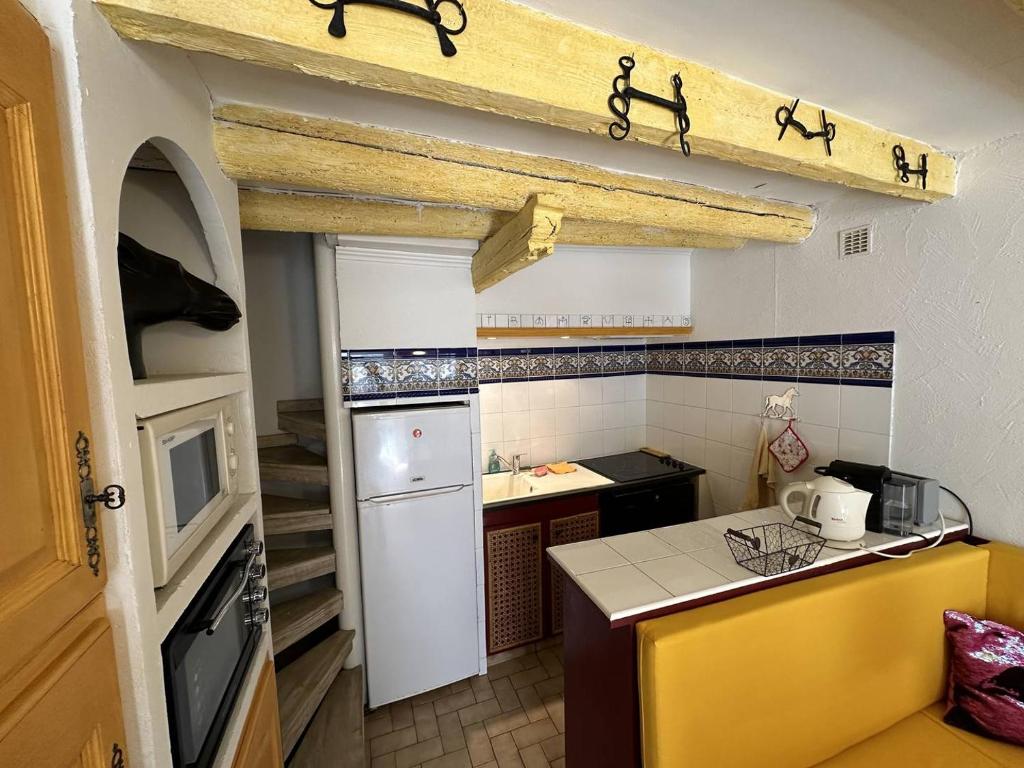 a kitchen with a white refrigerator and a sink at Maison de ville sur 2 niveaux - 2 chambres - terrasse tropézienne in Saintes-Maries-de-la-Mer