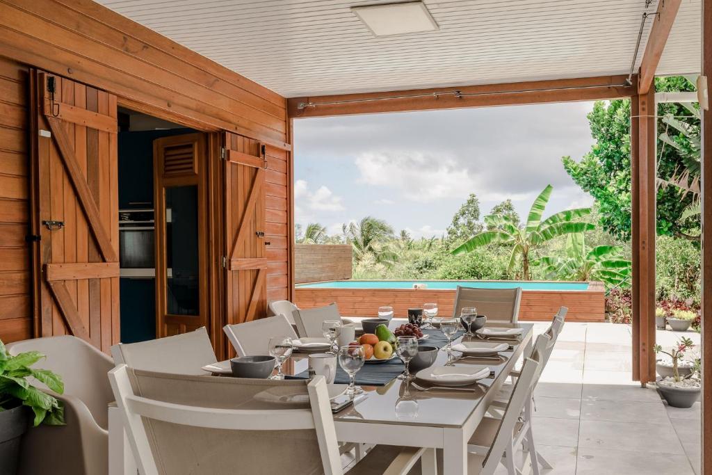 a dining room with a table and chairs on a patio at Villa Kassav'ry in Capesterre-Belle-Eau