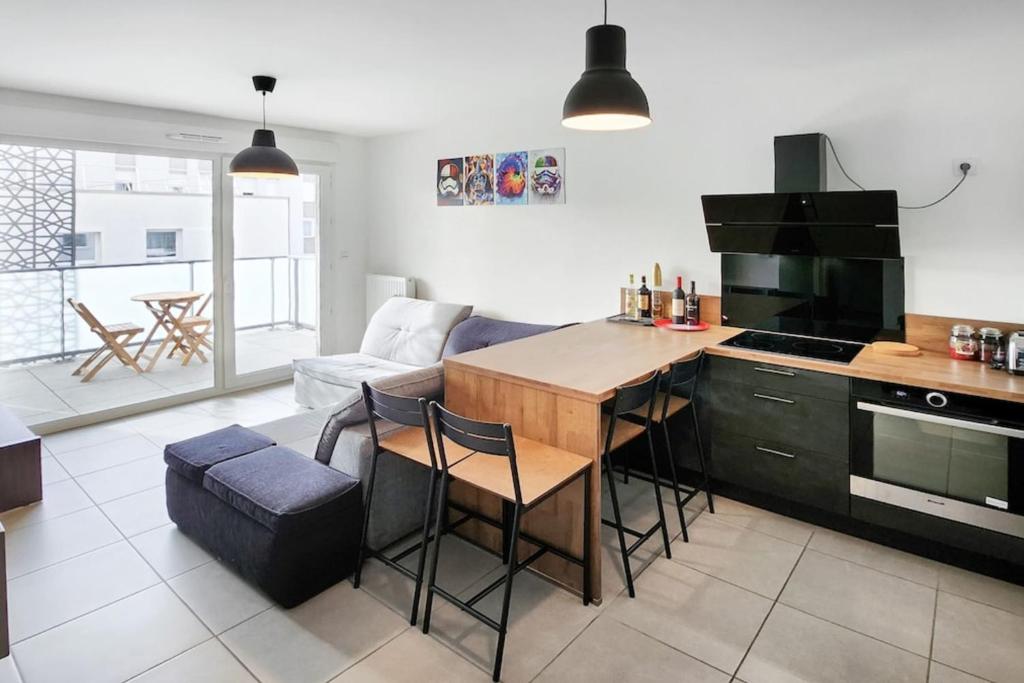 une cuisine et un salon avec un canapé et une table dans l'établissement Pixell Grand Lyon, à Villeurbanne