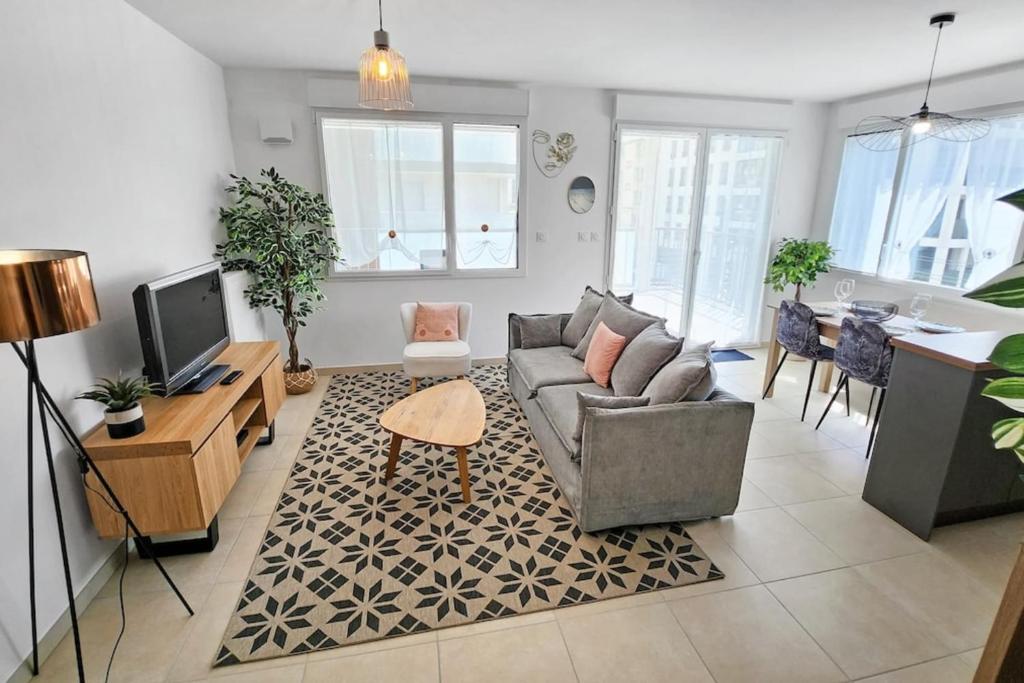 un salon avec un canapé et une télévision dans l'établissement Sous le cèdre, à Villeurbanne