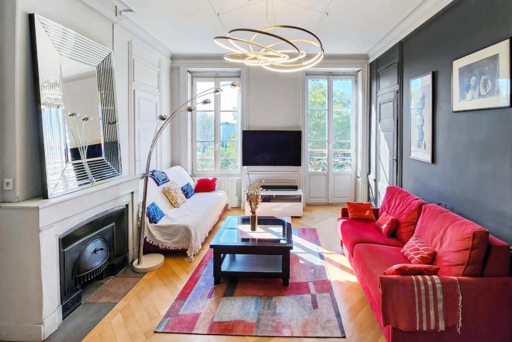 - un salon avec un canapé rouge et une cheminée dans l'établissement Place Carnot, à Lyon