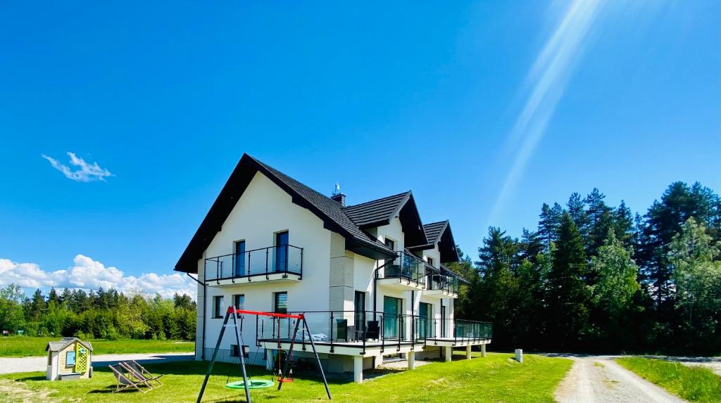 a house with a playground in front of it at Apartamenty Przełom Białki - plac zabaw, wiata grillowa in Białka Tatrzańska