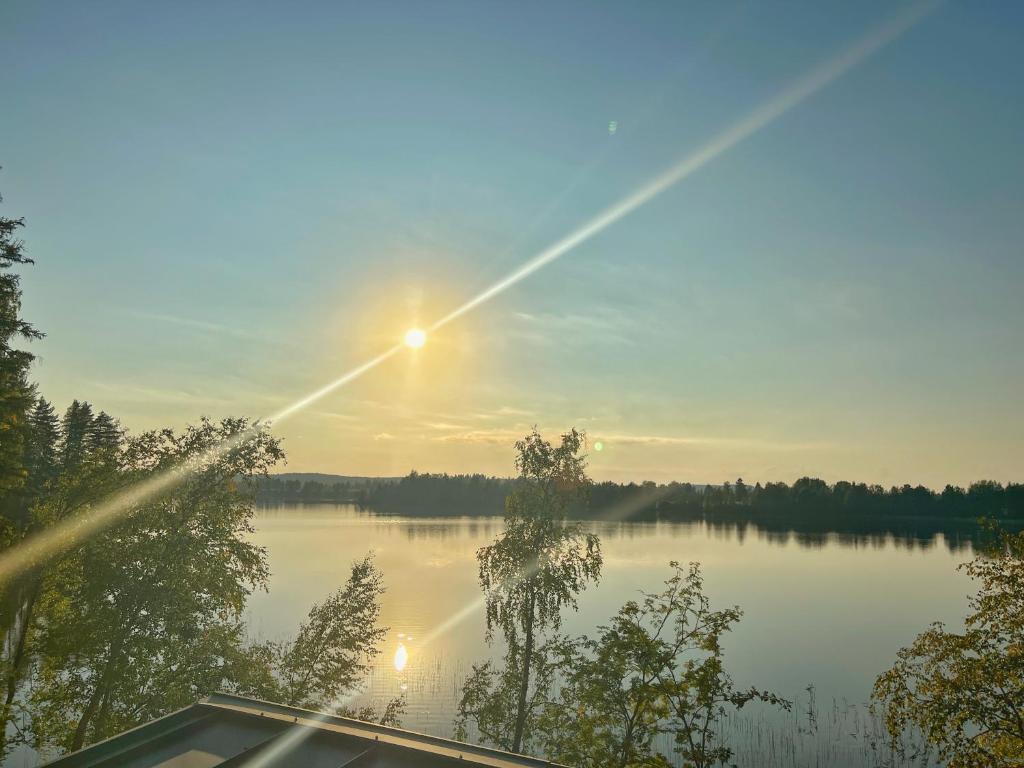 una vista de un lago con la puesta de sol sobre él en Villa Revontuli, en Jyväskylä