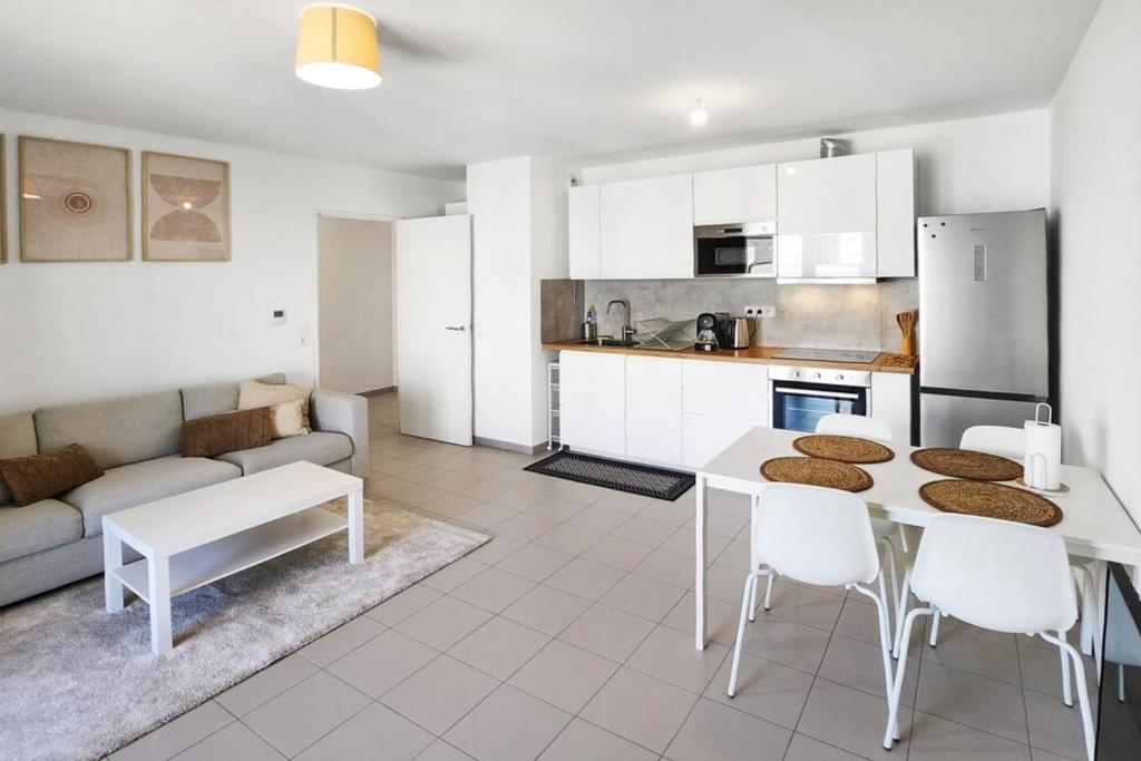 une cuisine et un salon avec une table et des chaises dans l'établissement Cosy Arborea, à Bron