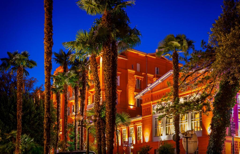 a building with palm trees in front of it at Hotel Imperial - Liburnia in Opatija