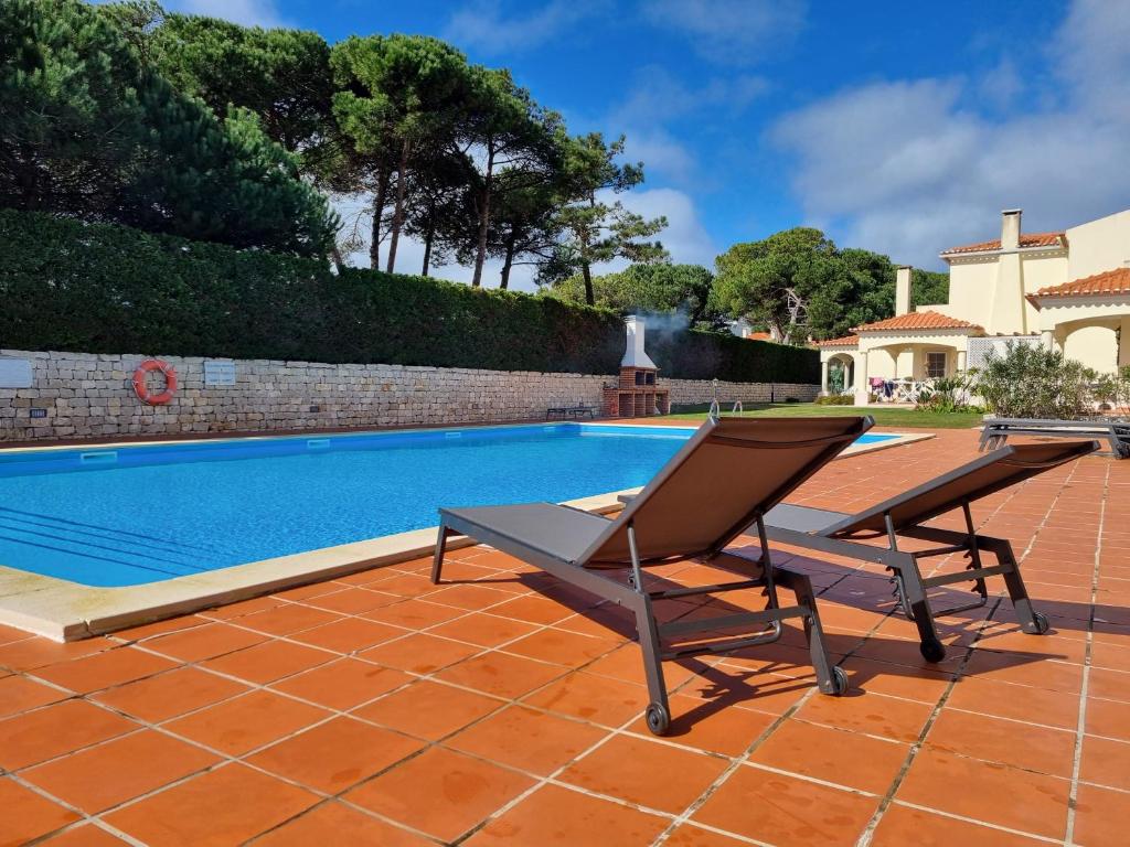 a chair sitting on a patio next to a swimming pool at Praia D'El Rey - Townhouse Dom Duarte in Amoreira