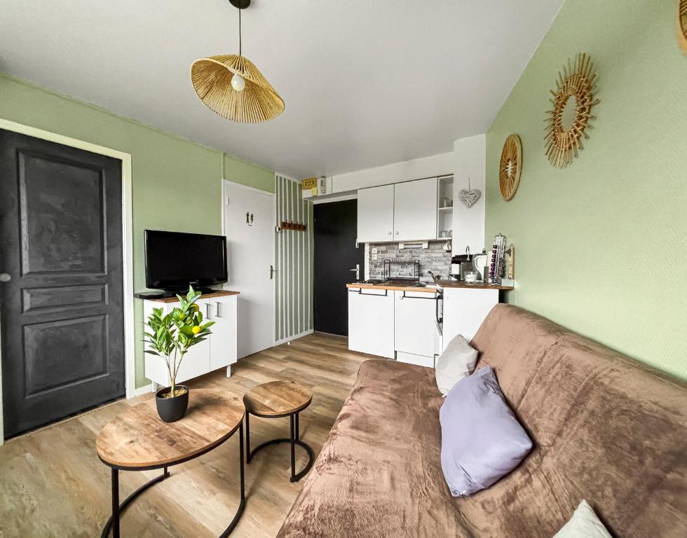 un salon avec un canapé et une table dans l'établissement Séjour paisible avec vue imprenable sur le Golf-self check-in, à Houlgate