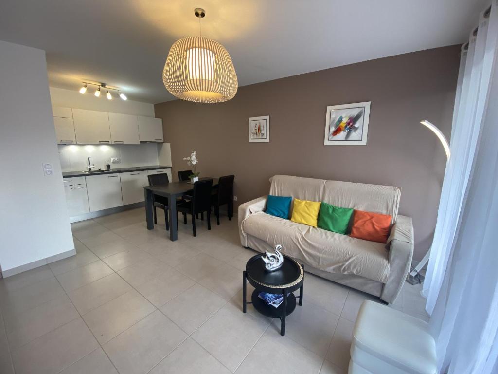 un salon avec un canapé et une table dans l'établissement Les Roses Appartement 3 etoiles, à Les Sables-dʼOlonne