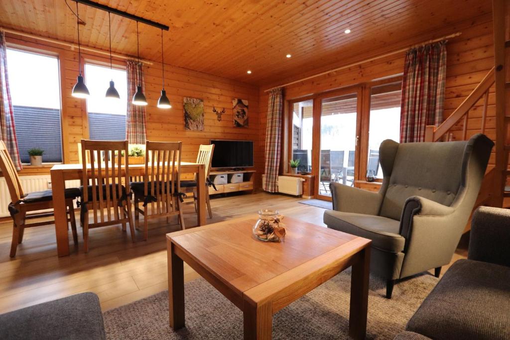 a living room with a table and a dining room at Feriendorf Blauvogel Blauvogel 001 in Hasselfelde