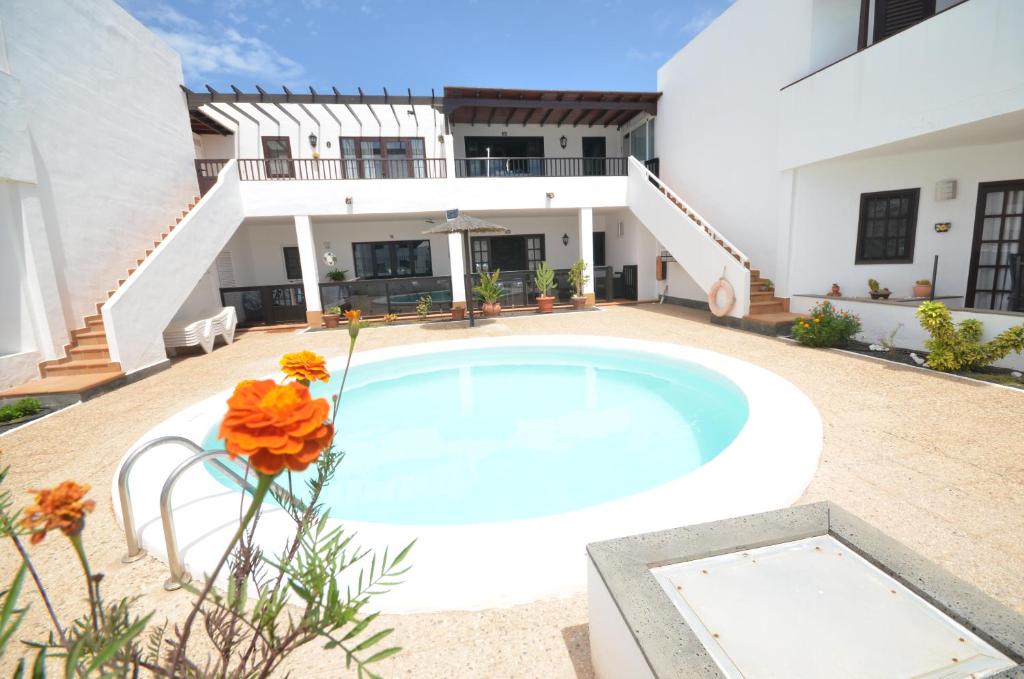 a swimming pool in front of a house at Sea Carnation Well Located, Pool & Terrace in Los Pocillos