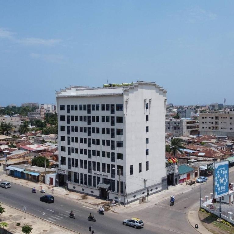 Un gran edificio blanco al costado de una calle. en Anhui hôtel, en Lomé