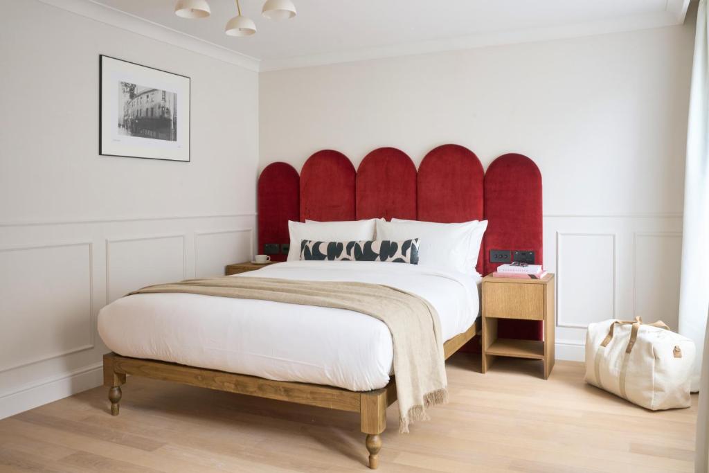 a bedroom with a large bed with a red headboard at The Store in Oxford