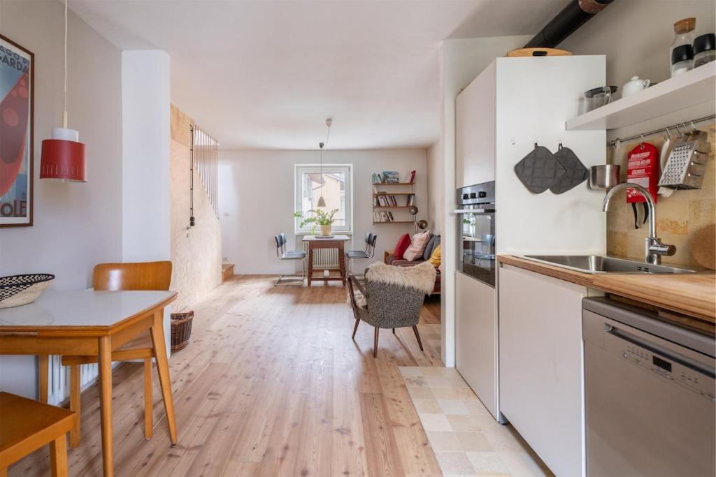a kitchen and living room with a table and chairs at Casa Claudia, stylish & spacious in Nago-Torbole