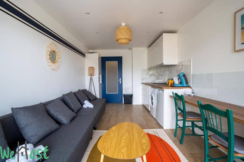 Una sala de estar con un sofá y una cocina. en TAMARIS -Proche mer-2p, en La Baule