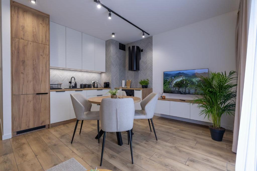 a kitchen and dining room with a table and chairs at VIP Apartamenty Borowa in Rzeszów