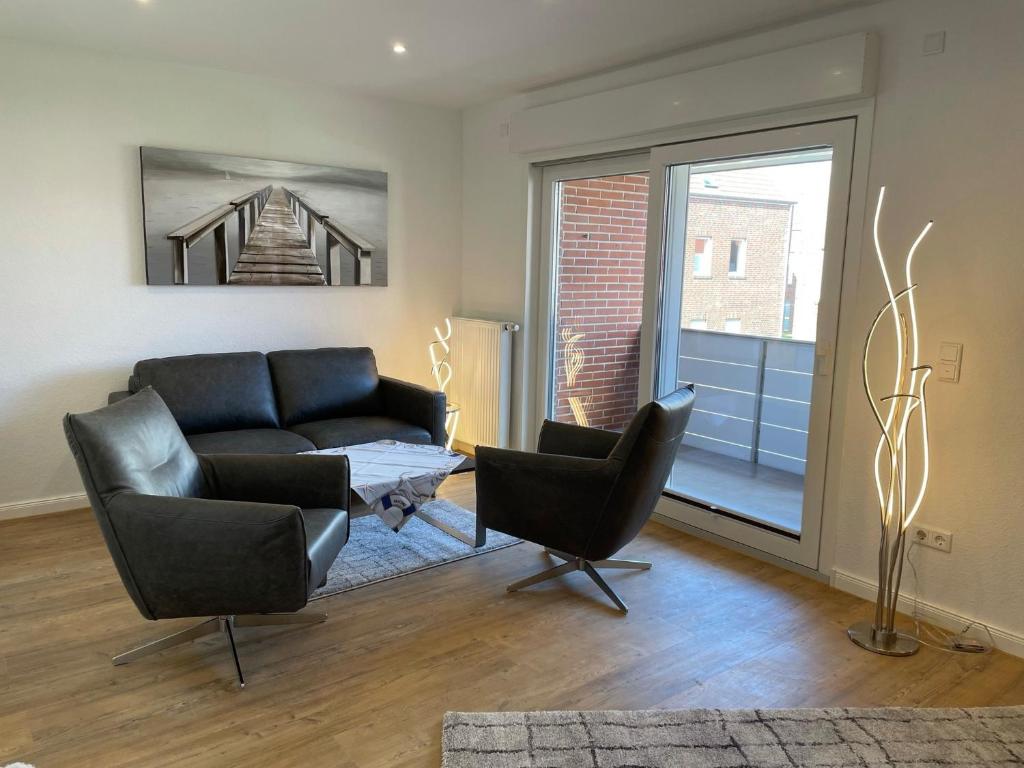 a living room with a couch and two chairs at Deichnähe A in Norden