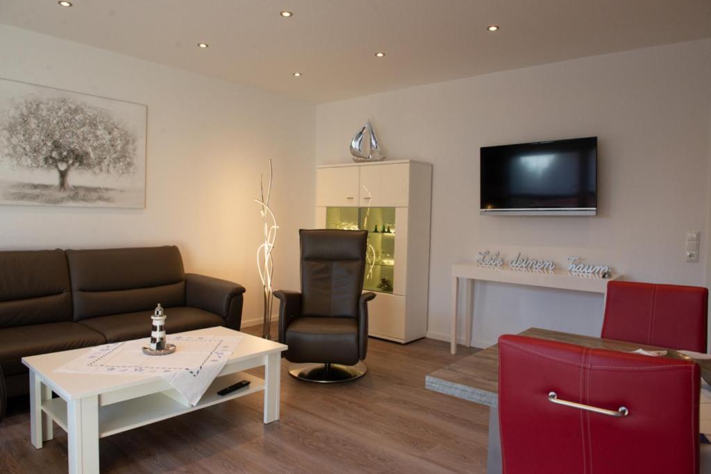 a living room with a couch and a table and a tv at Bounty in Norden