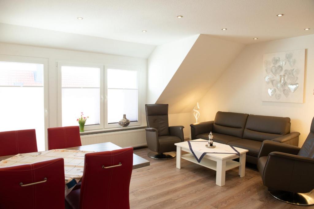 a living room with a table and a couch and chairs at Clipper in Norden
