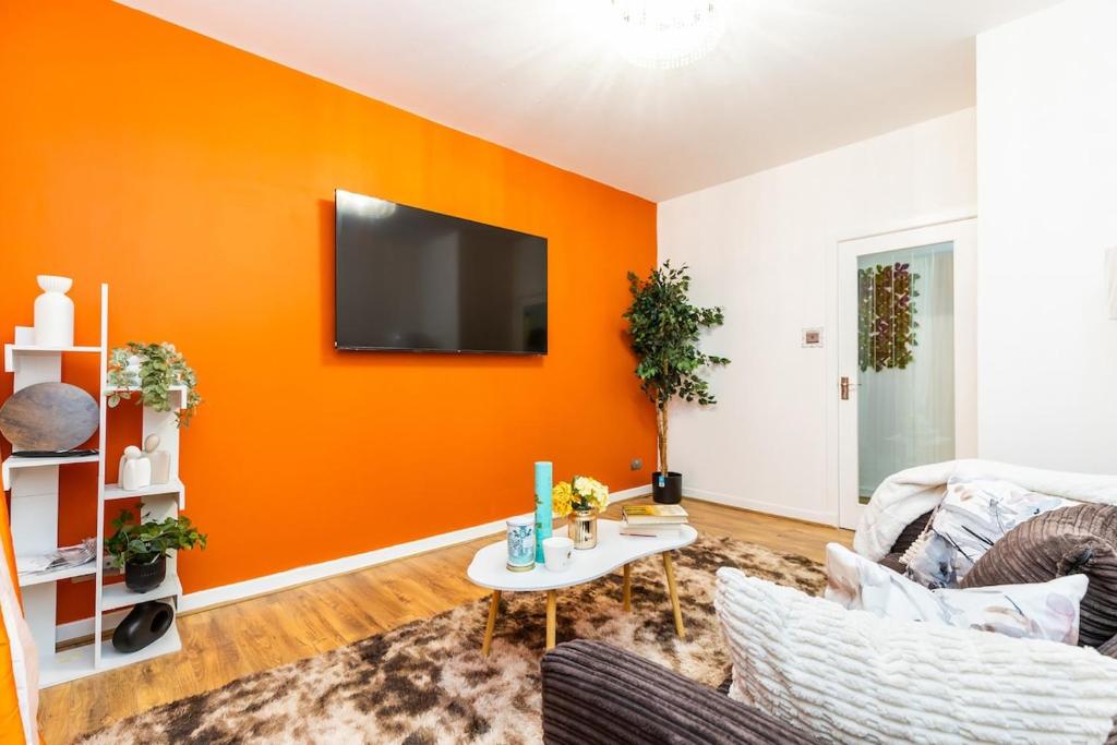 a living room with an orange accent wall at jaysapartment III in Aberdeen