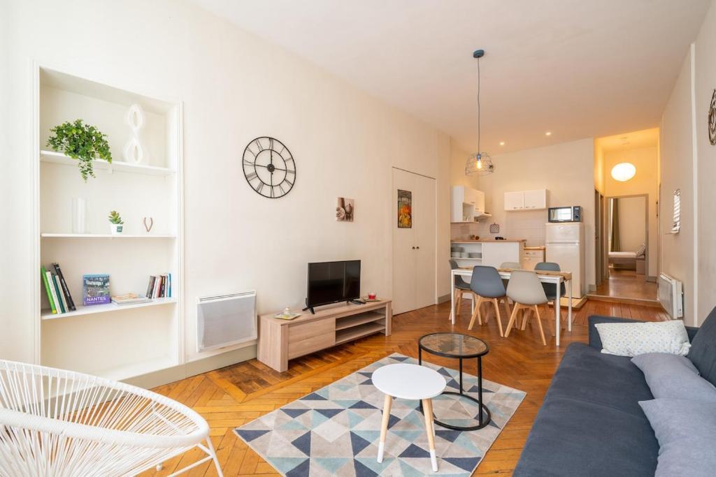 un salon avec un canapé bleu et une table dans l'établissement Saint nicolas - Basilique - centre ville, à Nantes