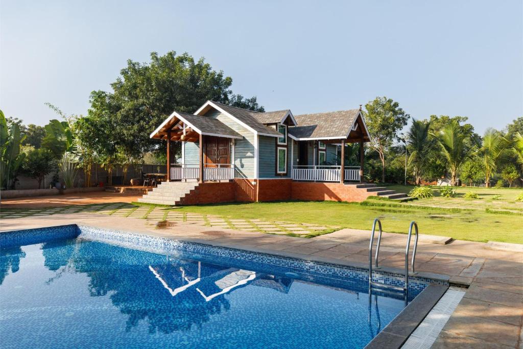 a house with a swimming pool in front of a house at TheSunlitHaven Pool GlassRooms Lawn in Raigīr