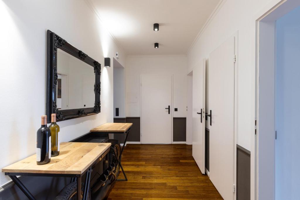 a hallway with a mirror and a table with wine bottles at Mokka Suite Design in Neumünster in Neumünster