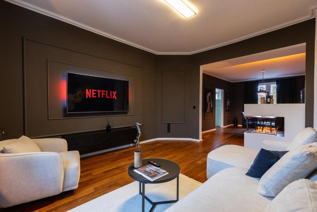a living room with two white couches and a tv at Mokka Suite Design in Neumünster in Neumünster
